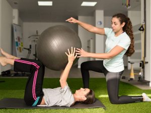 Physical therapist using exercise ball with patient